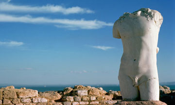 Ρωμαϊκό άγαλμα στα ερείπια της Καρχηδόνας και στο βάθος η θάλασσα.