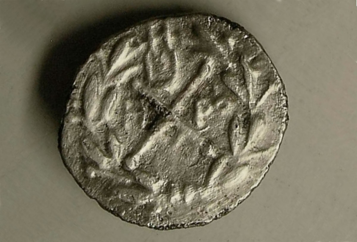 Εικ. 10. Ασημένιο νόμισμα Αχαϊκής Συμπολιτείας κομμένο στα Μέγαρα (175-160 π.Χ). Είχε αφιερωθεί στο ιερό του Απόλλωνος και της Αρτέμιδος. Το νόμισμα φέρει στην εικονιζόμενη όψη μικρή λύρα (πάνω), σύμβολο του Απόλλωνος. 
