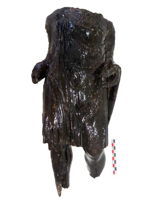 Ξύλινο περίοπτο γλυπτό όρθιας ενδεδυμένης ανδρικής μορφής. Αποκαλύφθηκε στη διάρκεια έργων της Αττικό Μετρό στον Πειραιά.