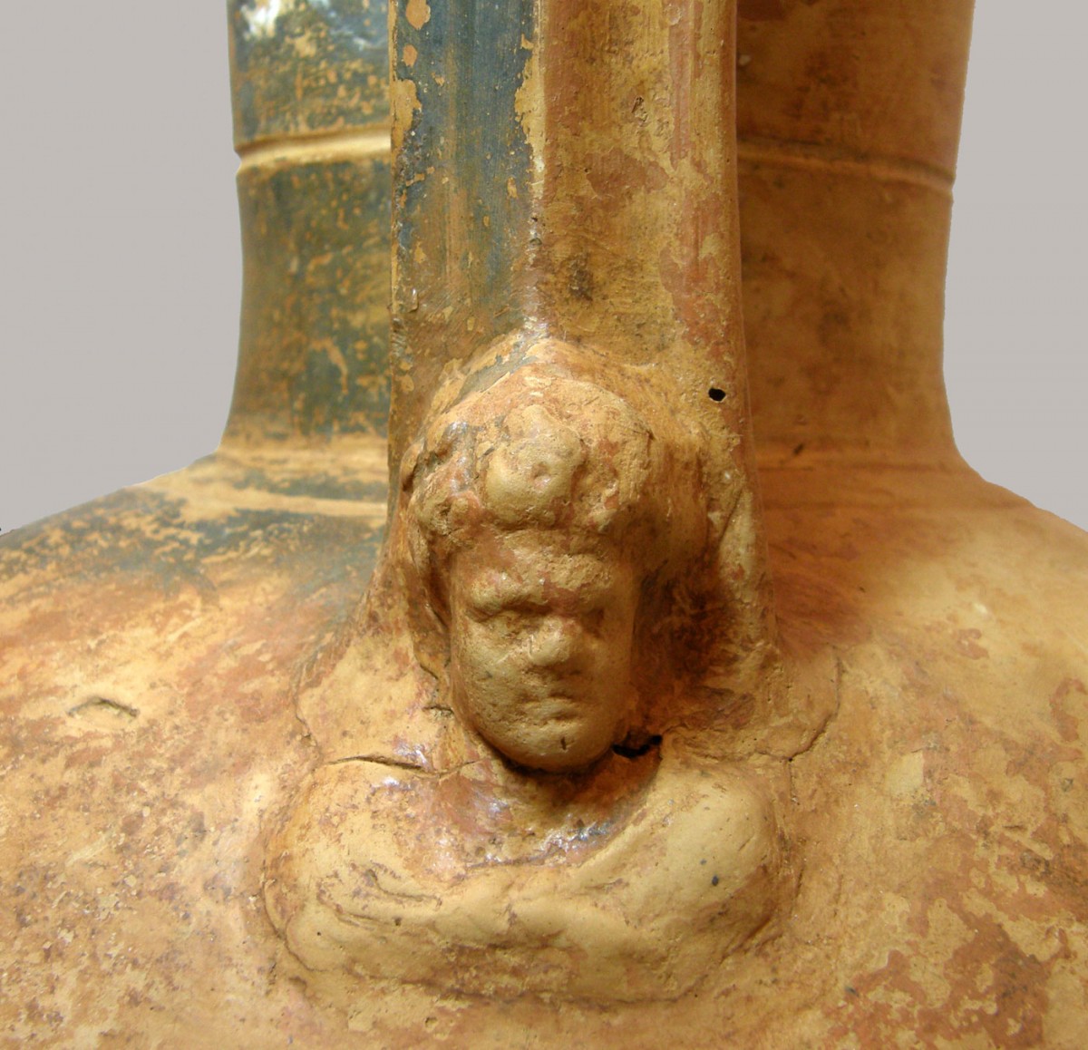 Οι λαβές του αμφορέα κοσμούνται με ανάγλυφο γυναικείο κεφάλι. Αρχαιολογικό Μουσείο Άρτας (φωτ. Εφορεία Αρχαιοτήτων Άρτας).