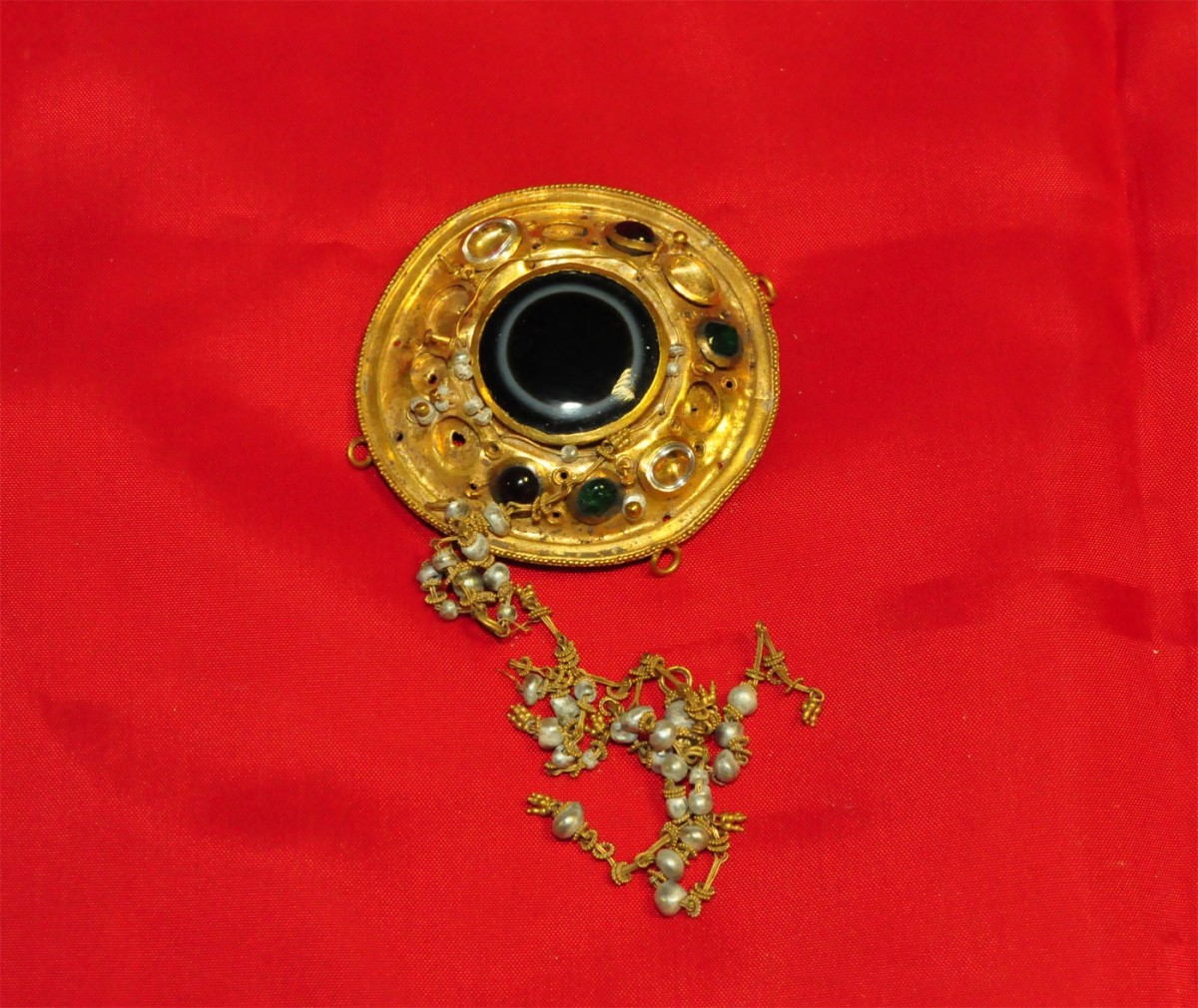 Χρυσή ασπιδίσκη με εντεθειμένους ημιπολύτιμους λίθους και μαργαριτάρια που βρέθηκε σε σοφίτα σπιτιού στην Αλεξάνδρεια Ημαθίας (φωτ. Ελληνική Αστυνομία).