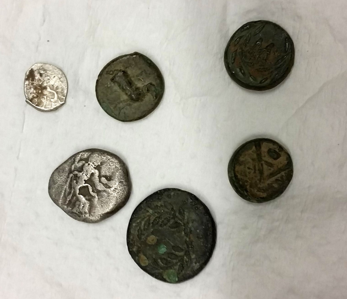 Μέρος των αρχαίων νομισμάτων που είχαν στην κατοχή τους τέσσερις άνδρες στην περιοχή της Κλειτορίας (φωτ. Ελληνική Αστυνομία). 
