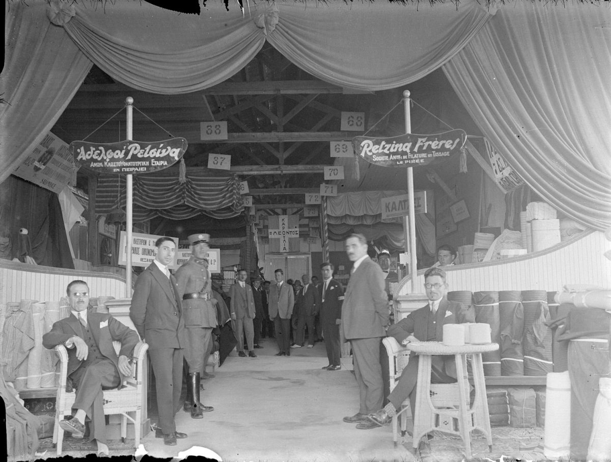 Βαφιαδάκης Γεώργιος, «Πρώτη Διεθνής Έκθεσις Θεσσαλονίκης: το περίπτερο της ανωνύμου κλωστοϋφαντουργικής εταιρίας των αδελφών Ρετσίνα, με έδρα τον Πειραιά», Θεσσαλονίκη, 1926. Πηγή: ΕΛΙΑ-ΜΙΕΤ, Αρχείο Γιώργου Βαφιαδάκη.