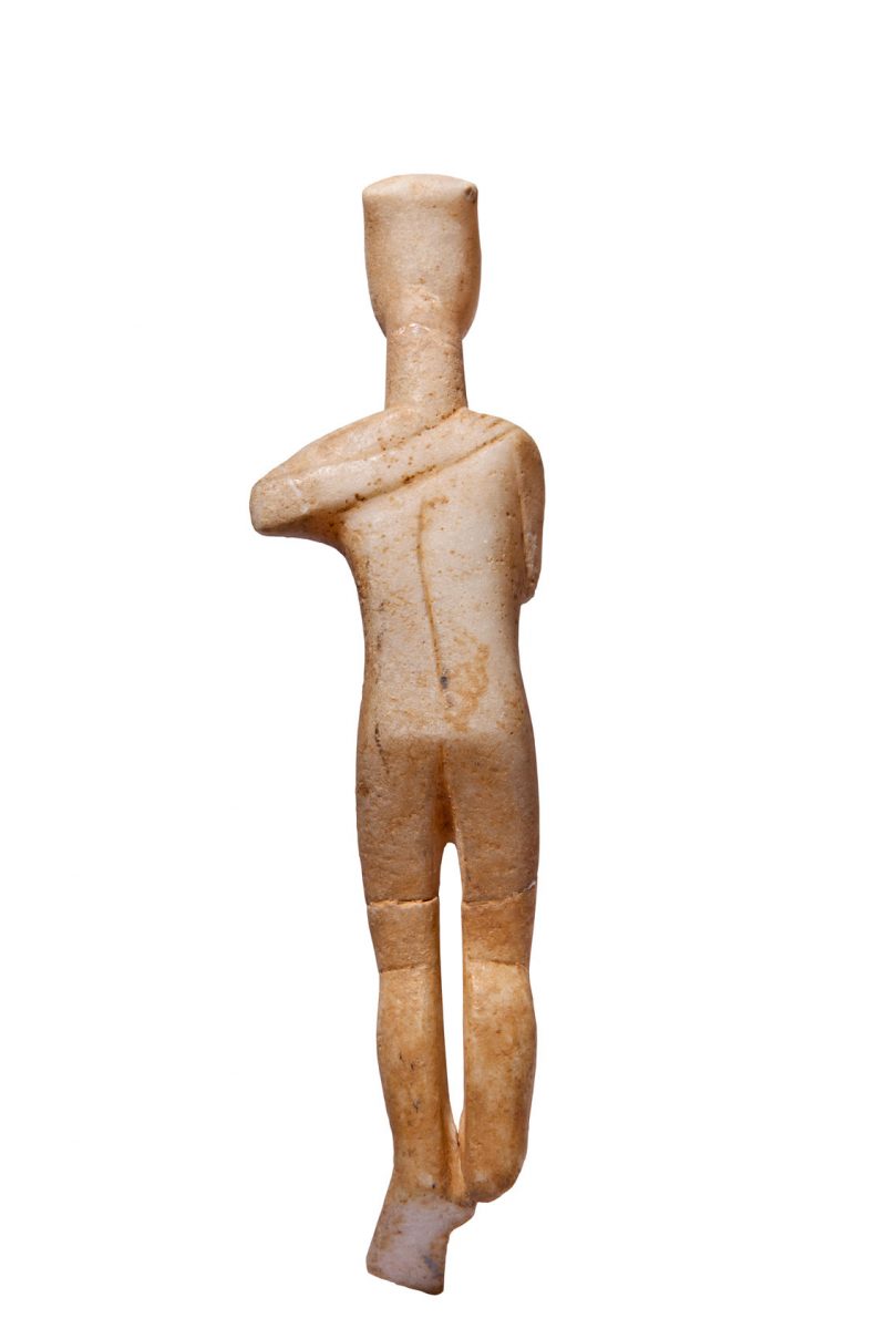 Μαρμάρινο γυναικείο ειδώλιο από σύμπλεγμα μορφών. Το χέρι στην πλάτη ανήκε σε άλλη μορφή, η οποία εναγκαλιζόταν τη σωζόμενη. Έπειτα από ατύχημα το σημείο θραύσης εξομαλύνθηκε και η θέση του χεριού αποδόθηκε εντελώς αφύσικα (περ. 2700-2400/2300 π.Χ.). Αθήνα, Μουσείο Κυκλαδικής Τέχνης, ΝΓ 330. Φωτ.: © Μουσείο Κυκλαδικής Τέχνης/Ειρ. Μίαρη.