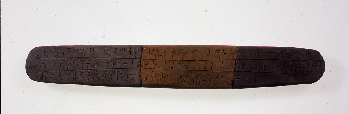 Πινακίδα Γραμμικής Β γραφής από το Ανάκτορο της Πύλου (13ος αι. π.Χ), όπου η λέξη ti-ri-po (τρίπους) προσδιορίζεται και από το λογόγραμμα του αντίστοιχου αγγείου. Η ταύτιση των λογογραμμάτων με τις ελληνικές λέξεις αποτέλεσε επιβεβαίωση ότι η συλλαβική Γραμμική Β απέδιδε την ελληνική γλώσσα. (© TAΠΑ/Εθνικό Αρχαιολογικό Μουσείο)