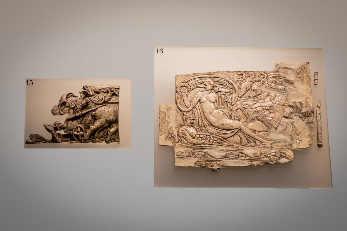 Αριστερά (15): τμήμα ελεφαντοστέινης πλάκας με ανάγλυφη παράσταση οπλίτη πάνω σε δίφρο τεθρίππου άρματος. Δεξιά (16): Ελεφαντοστέινο πλακίδιο. 4ος αι. μ.Χ. Φωτ: Γιώργος Αναστασάκης.