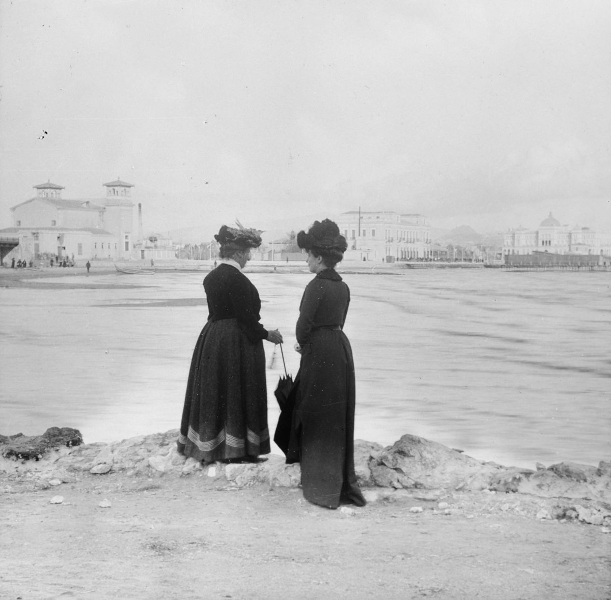 Νέο Φάληρο. Στο βάθος, από αριστερά στα δεξιά, το νέο θέατρο που κτίστηκε το 1896, το ξενοδοχείο του σταθμού με την προσθήκη του τρίτου ορόφου, το νεόδμητο ξενοδοχείο «Ακταίον» και η εξέδρα με τις καμπίνες των θαλάσσιων λουτρών. Φωτογραφία του A.L. Henderson.