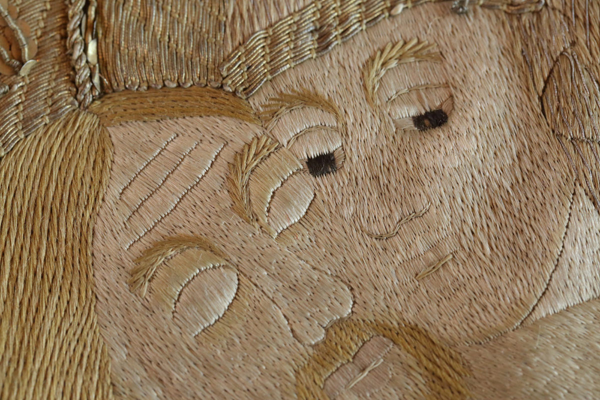 Τα κύρια πρόσωπα του Θείου Δράματος, ο Χριστός και η Θεοτόκος, λεπτομέρεια κεντητού επιταφίου (1733). Αναδεικνύονται η άψογη τεχνική και η χρονοβόρα εργασία δημιουργίας του έργου. Αποδίδεται σε εργαστήριο της Βιέννης.