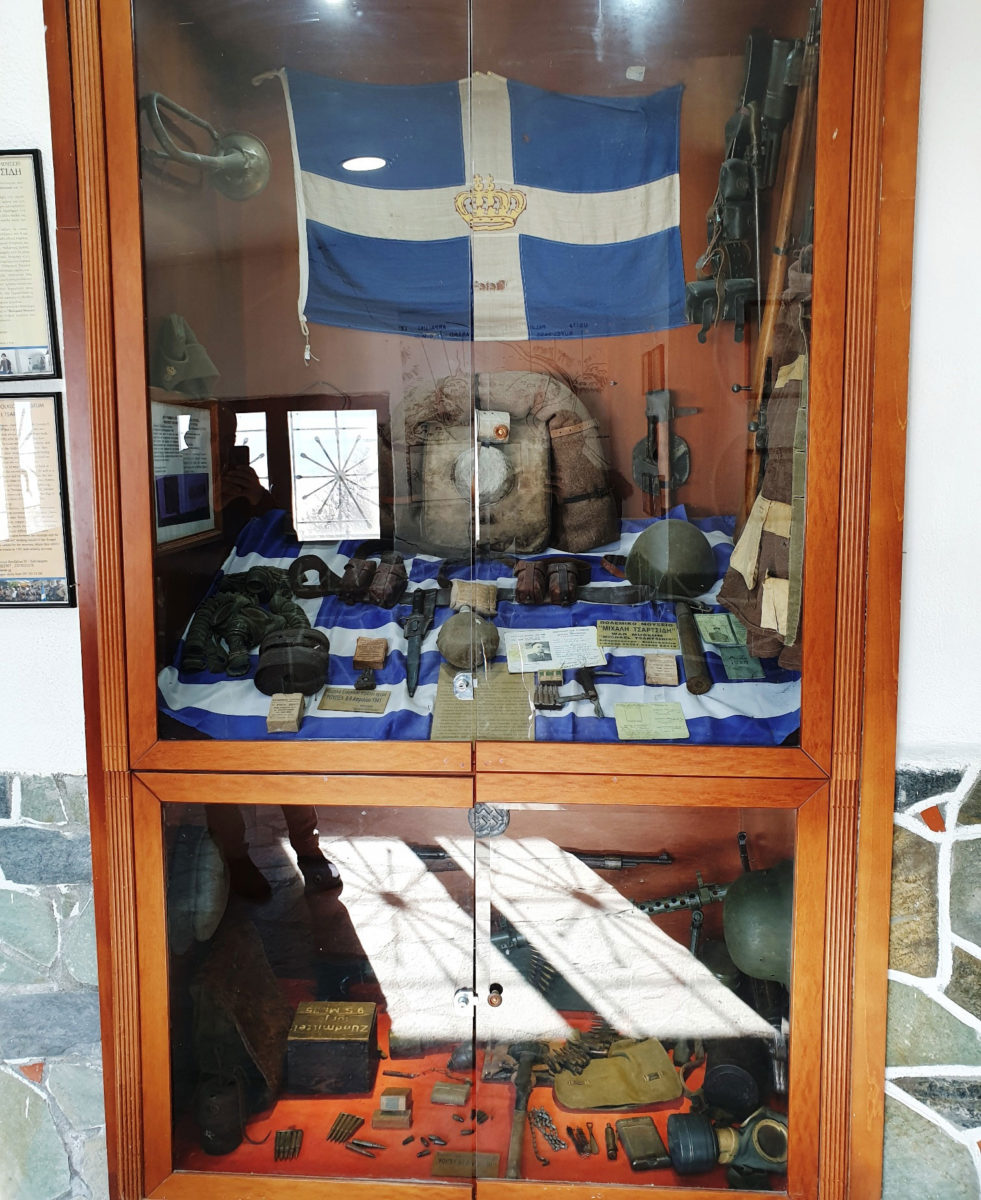 Τα λιγοστά αντικείμενα των στρατιωτών και μια ελληνική σημαία με τη βασιλική κορώνα που φυλάσσονται στην είσοδο της στοάς του οχυρού διοίκησης αποτελούν τεκμήρια της καθημερινότητας των Ελλήνων στρατιωτών (φωτ.: ΑΠΕ-ΜΠΕ).