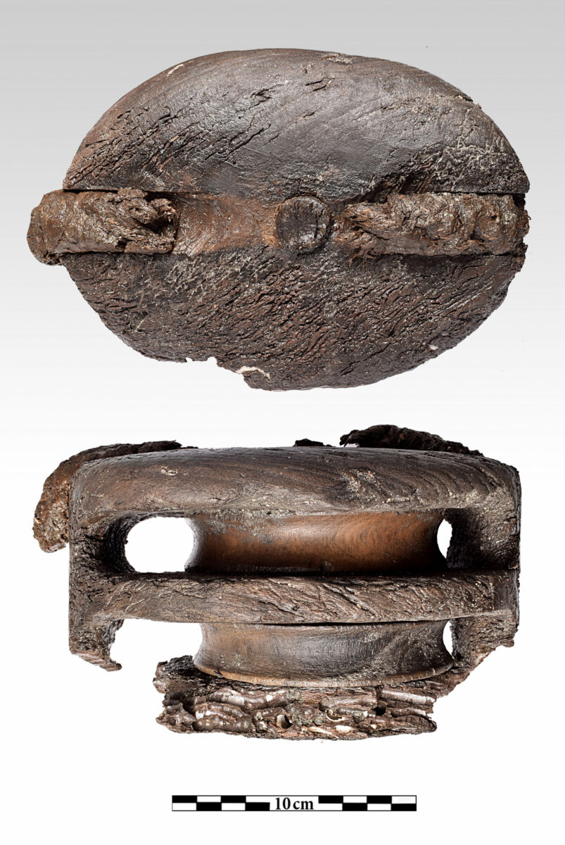 Ξύλινη τροχαλία με τμήμα του σχοινιού πρόσδεσής της κατά τη διαδικασία συντήρησης (φωτ.: Π. Βεζυρτζής).