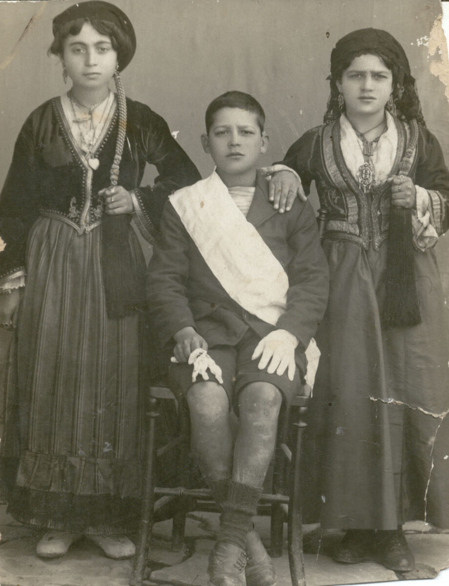 Άγνωστος φωτογράφος. Κορίτσια με φορεσιές «Αμαλία» (Πελοποννήσου) και αγόρι-σημαιοφόρος. Δεκαετία 1940. Πελοποννησιακό Λαογραφικό Ίδρυμα.