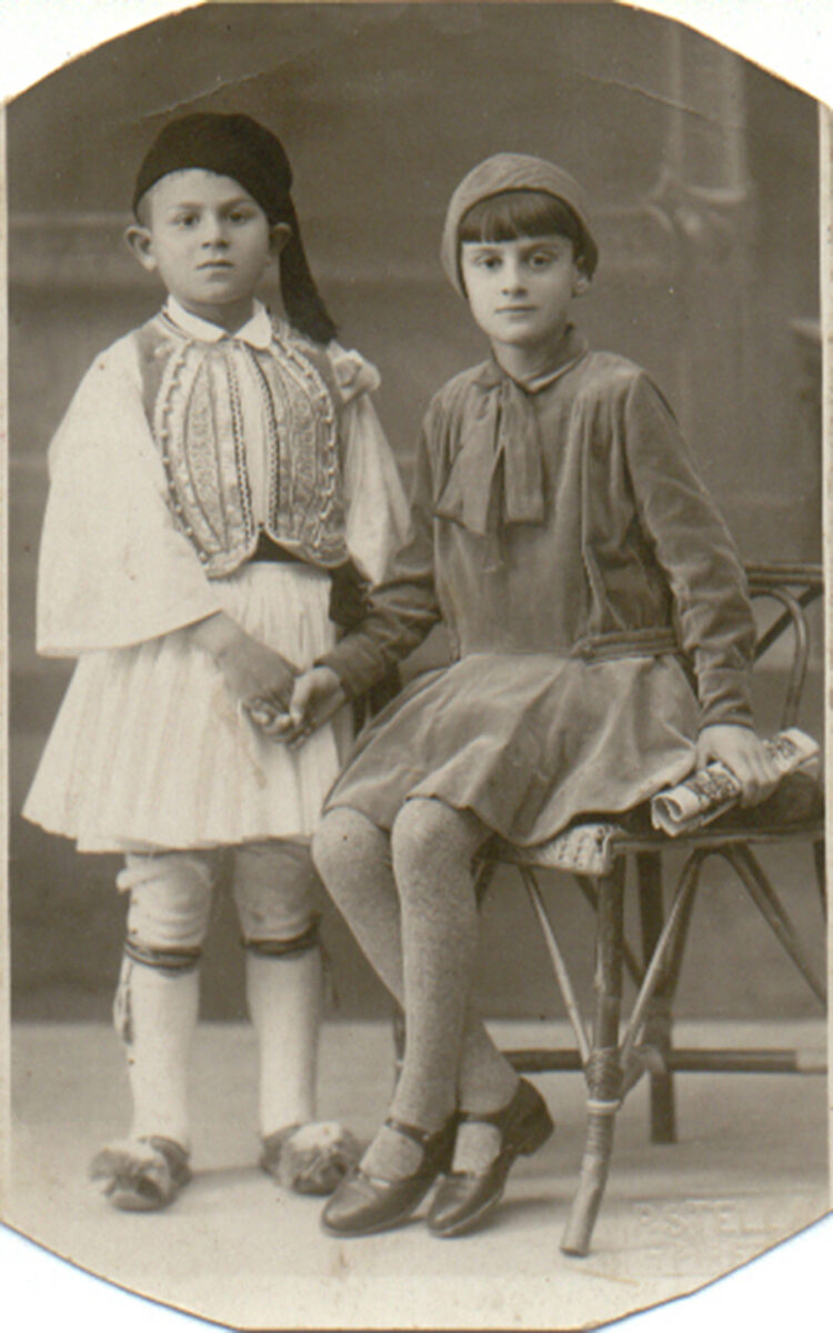 Φωτ. «Stella P.», Πειραιάς. Ευζωνάκι και κορίτσι με ένδυμα της δεκαετίας του 1940. Πελοποννησιακό Λαογραφικό Ίδρυμα.