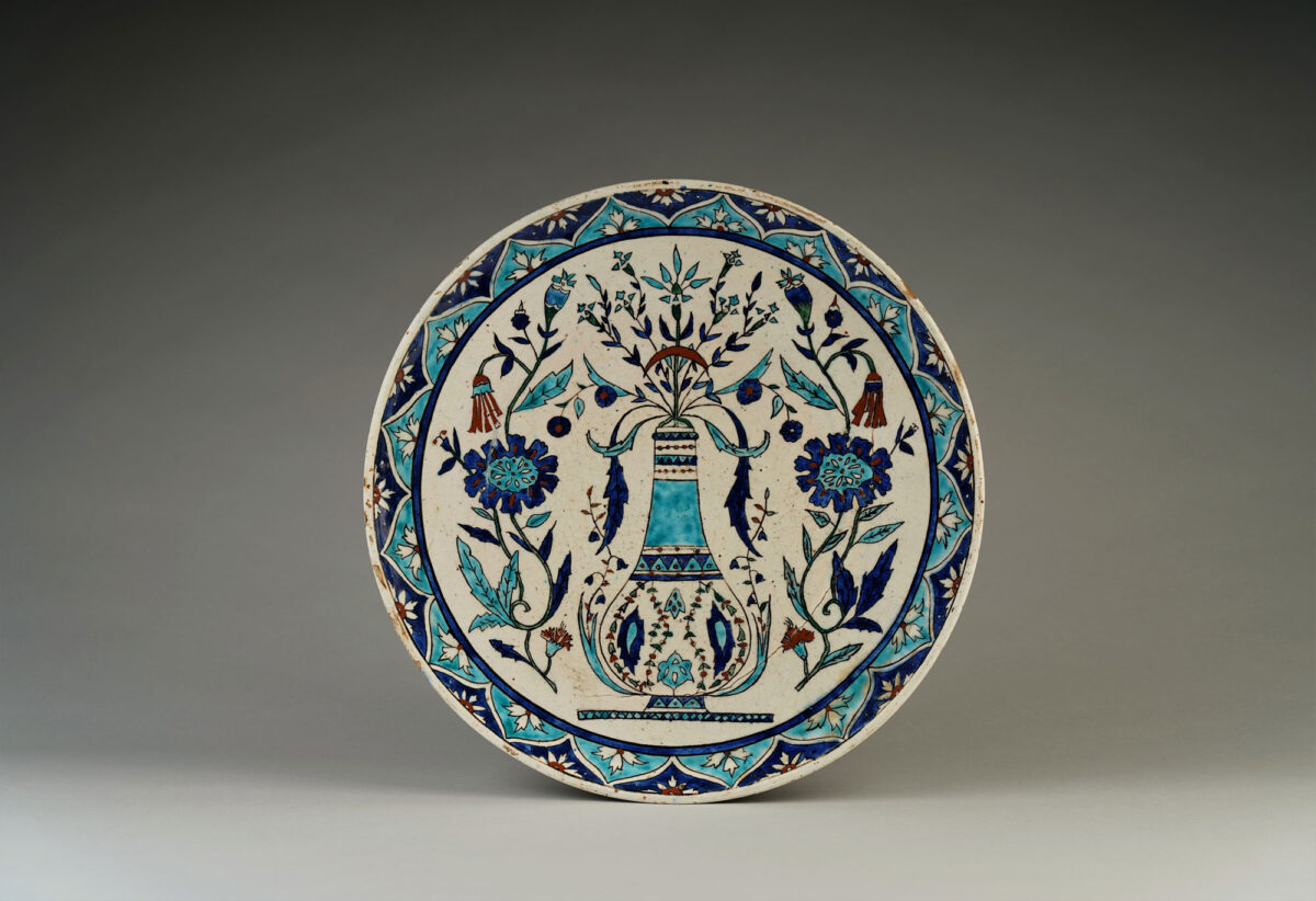 Πιάτο με παράσταση κανατιού για νερό πλαισιωμένη από φυτικά και άνθινα μοτίβα. Κιουτάχεια, τέλη 19ου – αρχές 20ού αιώνα. Διάμετρος: 37 εκ. Ιδιωτική συλλογή. 