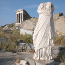 Το άγαλμα της Αθηναίας Διοδώρας αφιερωμένο στον Σάραπι, την Ίσιδα και τον Άνουβι από τον σύζυγο και τα παιδιά της, και ο ναός της Ίσιδας στο Σαραπιείο Γ (© EFA − J.-Ch. Moretti).