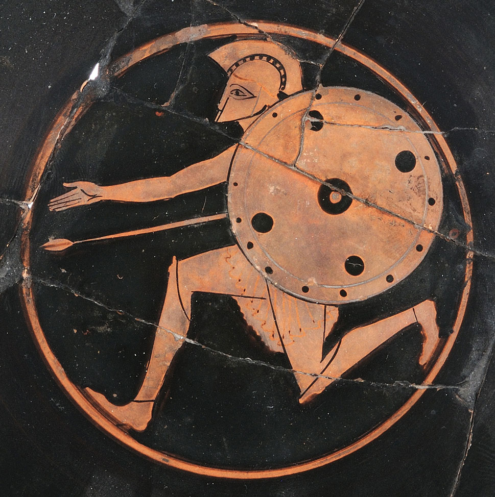 Λεπτομέρεια από αττική ερυθρόμορφη κύλικα με απεικόνιση οπλίτη, τέλη 6ου αι. π.Χ. (αρ. συλλ. Δ 853). Πηγή εικόνας: Μουσείο Παύλου και Αλεξάνδρας Κανελλοπούλου.