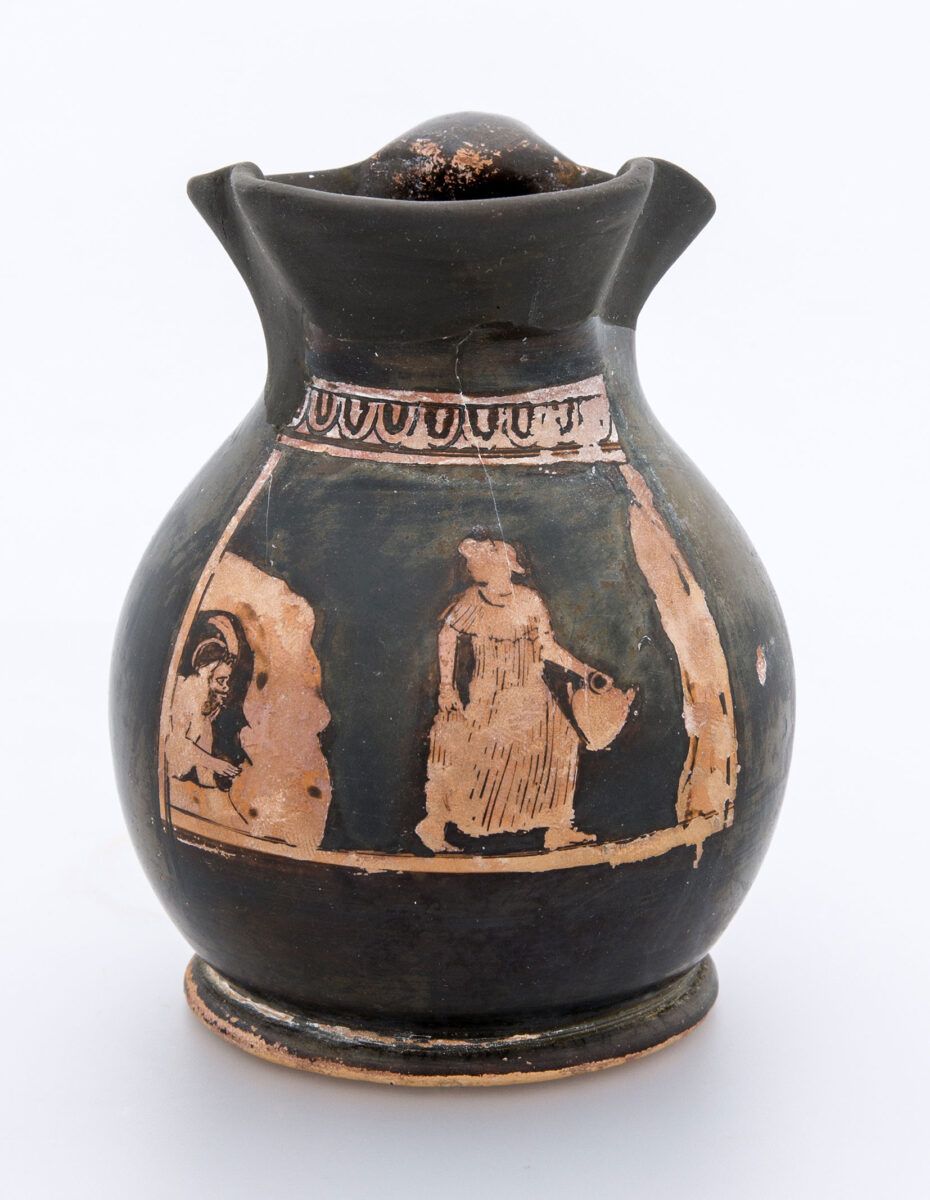 Αττικός ερυθρόμορφος χους (μικρό κανάτι) με παράσταση Πάνα που προβάλλει ημικλινής μέσα από σπήλαιο και κοιτάζει νεανική γυναικεία μορφή, η οποία βαδίζει κρατώντας υδρία προς κατακόρυφο βράχο, απ’ όπου αναβλύζει νερό. Πιθανόν από την Ελευσίνα. 450-425 π.Χ. Μουσείο Μπενάκη, αρ. ευρ. 38145.