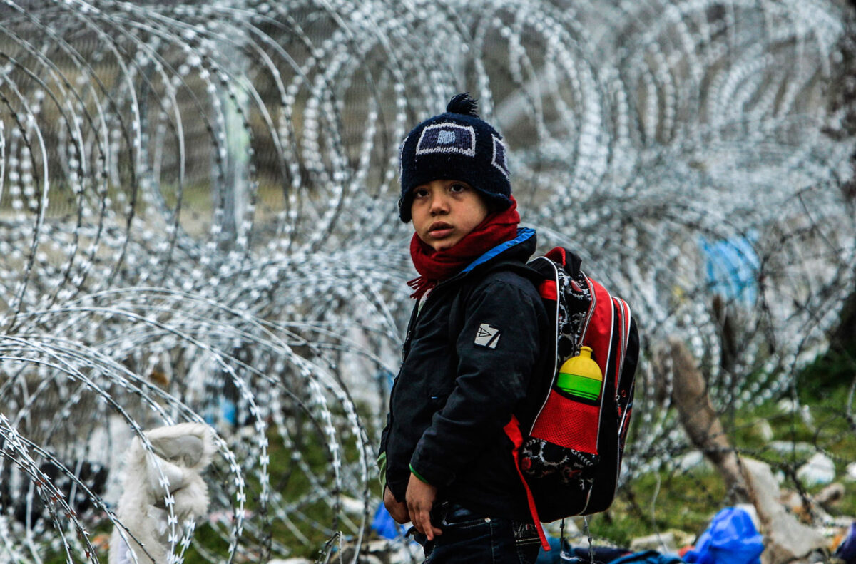 Δημήτρης Μεσσίνης, προσφυγόπαιδο από τη Συρία στέκεται μπροστά στα συρματοπλέγματα που τοποθέτησαν οι αρχές της Βόρειας Μακεδονίας στην Ειδομένη (4 Μαρτίου 2016).