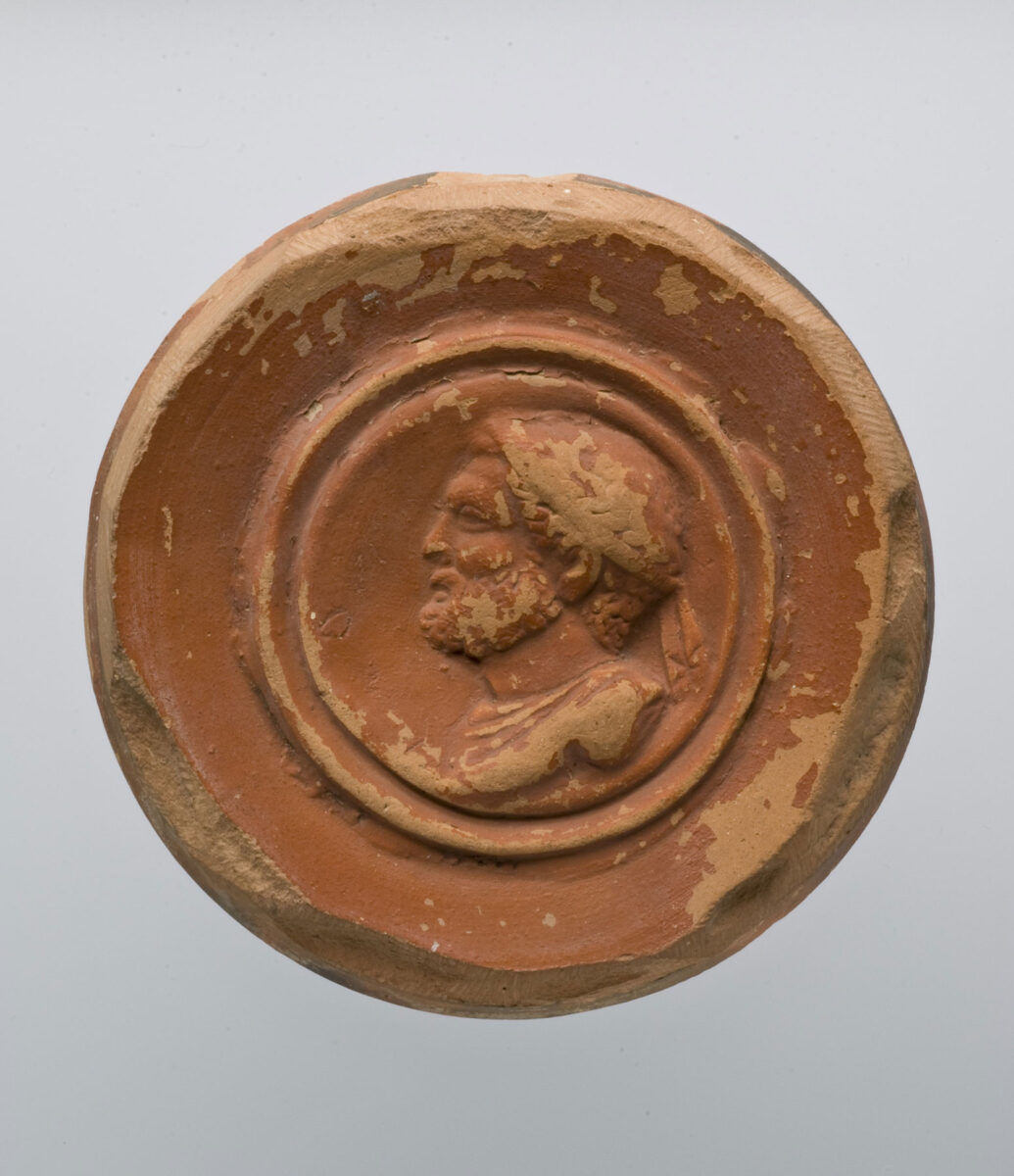 Έμβλημα από πυθμένα πήλινου αγγείου του 3ου αι. μ.Χ. με προτομή γενειοφόρου και θωρακοφόρου Φιλίππου Β'. Πηγή εικόνας: Μουσείο Κυκλαδικής Τέχνης.