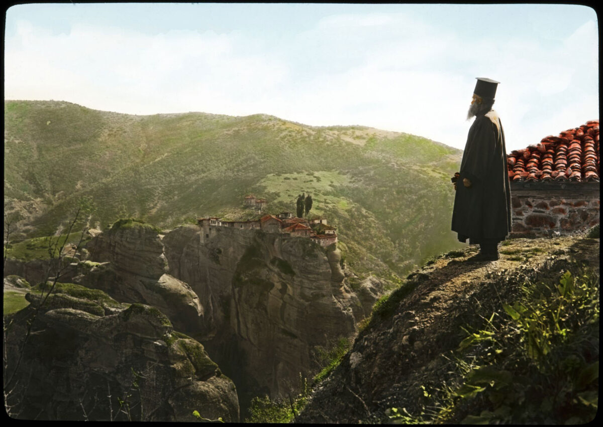 Μετέωρα. Μοναχός στέκεται στο βράχο της μονής του Μεγάλου Μετεώρου και αγναντεύει τη μονή Βαρλαάμ που βρίσκεται στον απέναντι βράχο.