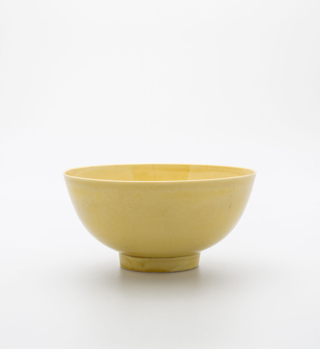 Κούπα, πορσελάνη με κίτρινη εφυάλωση, επιγραφή έξι ιδεογραμμάτων εντός διπλού κύκλου σε μπλε του κοβαλτίου κάτω από την εφυάλωση, στη βάση, που μεταφράζεται ως «Φτιαγμένο στη Μεγάλη Δυναστεία Τσινγκ κατά την περίοδο του αυτοκράτορα Κανγκσί», Τσιντετζέν, Κανγκσί (1662-1722 μ.Χ.), διάμ. 12,7 εκ. Μουσείο Μπενάκη 2771, δωρεά Γεώργιου Ευμορφόπουλου.