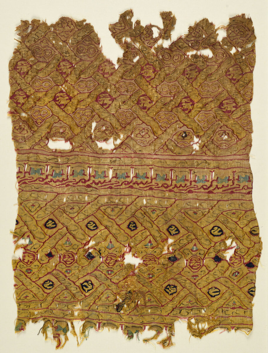 Τμήμα μεταξωτού υφάσματος με σχηματοποιημένη επιγραφή. Εποχή Φατιμιδών. Αίγυπτος 12ος αι. Ύψος 25 εκ., πλάτος 31 εκ. Μουσείο Μπενάκη 15178.