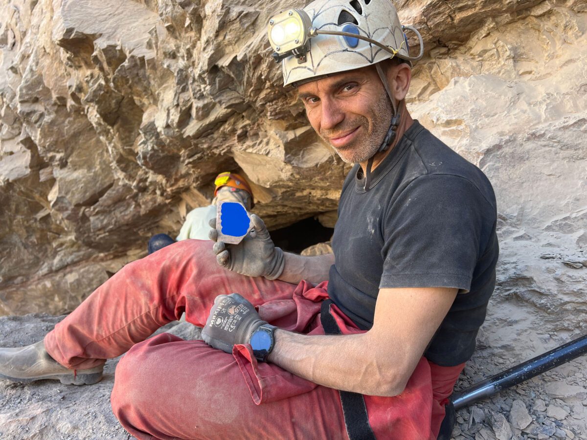 Η στιγμή της ανεύρεσης του ενεπίγραφου οστράκου στο εσωτερικό του μεταλλείου χρυσού. Το περιεχόμενό του έχει καλυφθεί διότι αποτελεί αδημοσίευτο υλικό. Πηγή εικόνας: Ανασκαφική Ομάδα Ανατολικής Ερήμου Αιγύπτου.