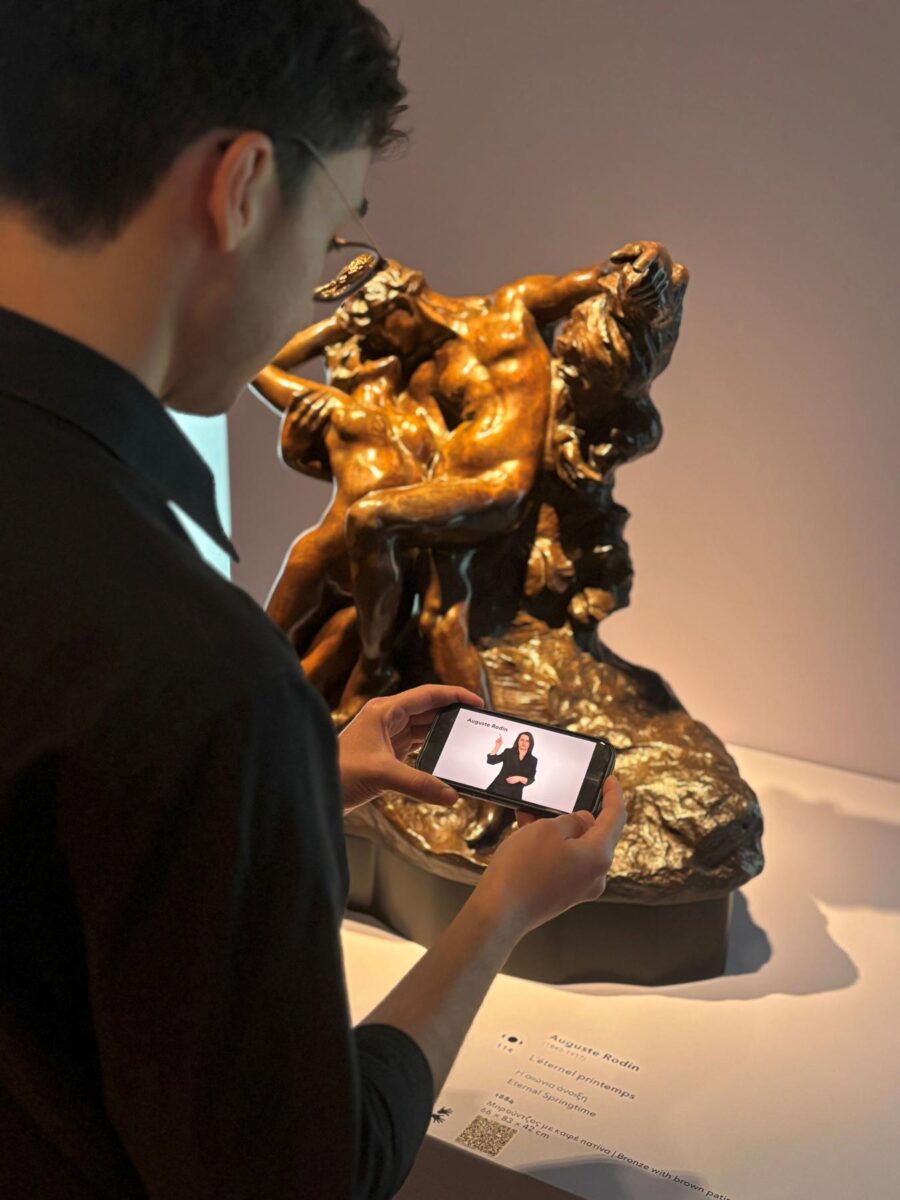 Οι επισκέπτες της μόνιμης Συλλογής του Ιδρύματος Β&Ε Γουλανδρή μπορούν να παρακολουθήσουν τις ξεναγήσεις στην Ελληνική Νοηματική Γλώσσα στους εκθεσιακούς χώρους, σκανάροντας με smartphone ή tablet τα ειδικά QR codes που βρίσκονται δίπλα στα αντίστοιχα έργα. Πηγή εικόνας: Ίδρυμα Β&Ε Γουλανδρή.