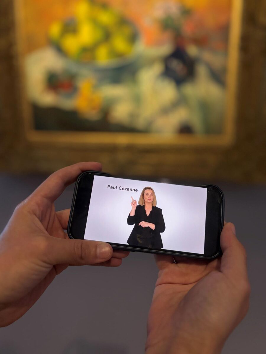 Οι επισκέπτες της μόνιμης Συλλογής του Ιδρύματος Β&Ε Γουλανδρή μπορούν να παρακολουθήσουν τις ξεναγήσεις στην Ελληνική Νοηματική Γλώσσα στους εκθεσιακούς χώρους, σκανάροντας με smartphone ή tablet τα ειδικά QR codes που βρίσκονται δίπλα στα αντίστοιχα έργα. Πηγή εικόνας: Ίδρυμα Β&Ε Γουλανδρή.