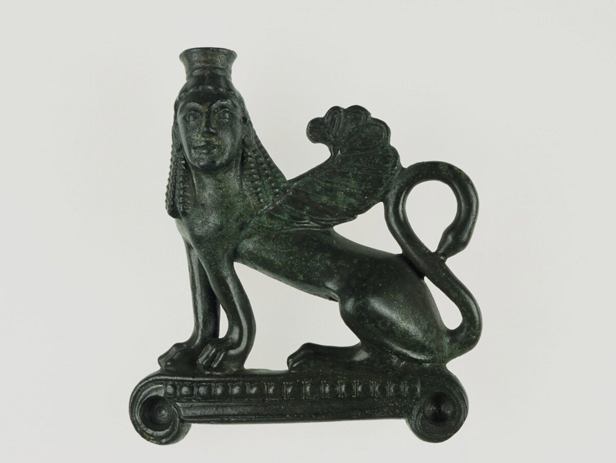 •	Eιδώλιο σφίγγας. Mάλλον από τη διακόσμηση σκεύους ή επίπλου. Γύρω στο 540 π.X. Από την Κρήτη (Ιδαίο Άντρο). Εθνικό Αρχαιολογικό Μουσείο, Συλλογή Έργων Μεταλλοτεχνίας.