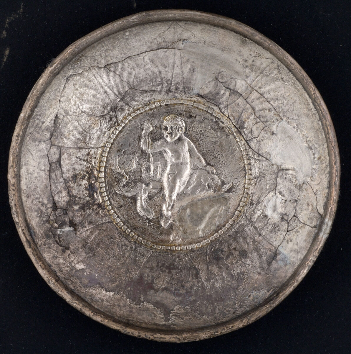 Ασημένιο πινάκιο διακοσμημένο με μυθολογική σκηνή που απεικονίζει τον Έρωτα να ιππεύει θαλάσσιο τέρας. Αίγυπτος. Ύστερος 6ος – αρχές 7ου αιώνα. Διάμ. 12,9 εκ. Μουσείο Μπενάκη, αρ. ευρ. 11451.